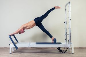 pilates reformer workout exercises man at gym indoor.