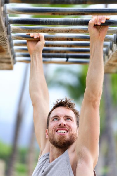 Man hanging from monkey bars