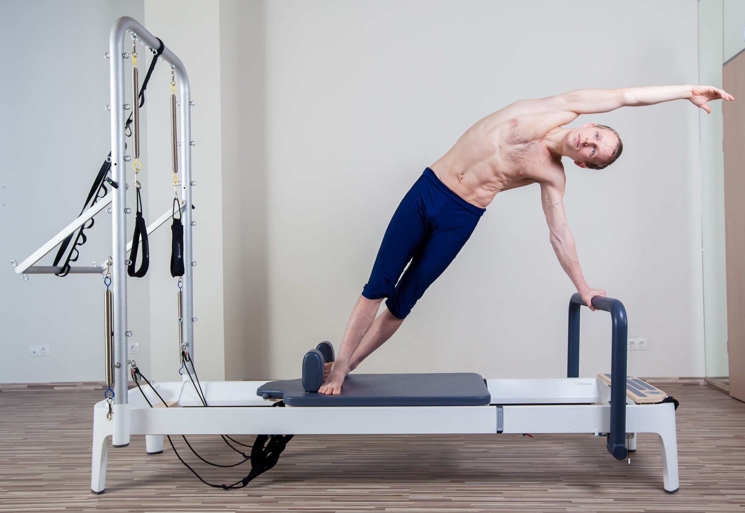 Pilates reformer workout exercises man at gym indoor